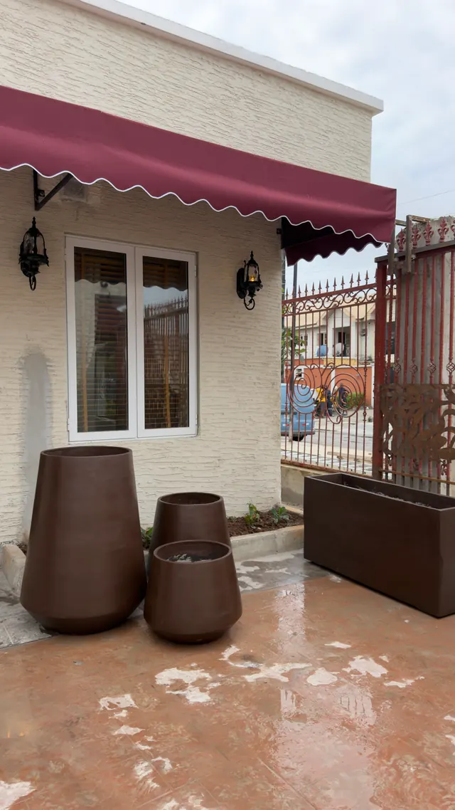 Brown handcrafted planters outside a home